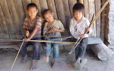 photo: Tsimane children on a bench with their bows and arrows.